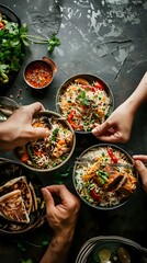 A vibrant meal shared among friends, featuring bowls of rice and colorful vegetables.