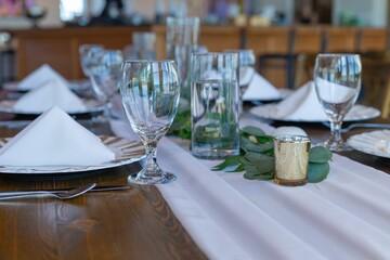 Elegant table setting with glassware and greenery.