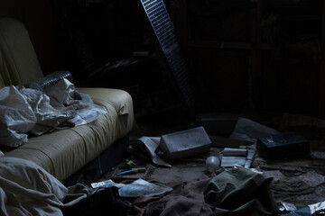 薄暗い光の中、荒れたソファのある室内