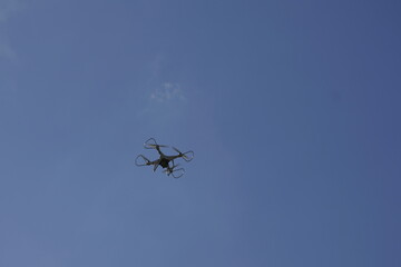 Silhouetted Drone Flying Against a Clear Blue Sky
