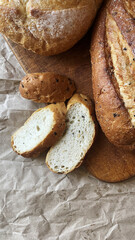 Close up of freshly baked delicious organic homemade wholemeal bread with crispy crust and cut slices on wooden board in bakery kitchen
