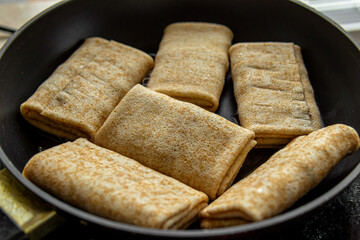 Cooking frozen pancakes with filling in frying pan