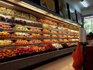 A grocery store aisle filled with various types of fruits.