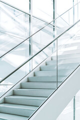 Obraz premium contemporary glass staircase in a modern building illuminated with vibrant yellow and blue light. The sleek metal railings reflect the vivid colors