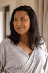 Smiling Senior woman in cozy sweater looking away, enjoying peaceful moment at home