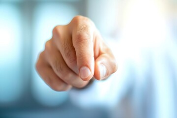 Close-up of a hand pointing forward with a blurred background.