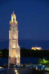 Fototapeta premium Illuminated Old Port Montreal Clock Tower by the River at Dusk