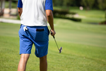 a white golf ball on a tee and a green field ready to be hit with a wood golf stick as a start to a game of golf.