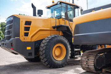 Yellow tractor at the back. Construction equipment.