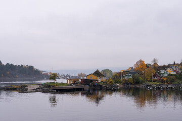 Obraz premium Oslo, Norway - October 20, 2024: Oslofjord (Oslofjorden), view of summer houses and cottages. Frame houses for recreation. Hut among the forest and rocks. Multicolored private houses.