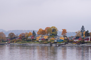 Oslo, Norway - October 20, 2024: Oslofjord (Oslofjorden), view of summer houses and cottages. Frame houses for recreation. Hut among the forest and rocks. Multicolored private houses.