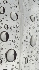 Close-up shot of rainwater droplets on a stainless steel platform, creating a fresh and reflective surface. The water droplets glisten against the smooth metal, forming a calming, natural texture.