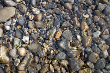 Dieses Foto zeigt eine Szenerie, in der zahlreiche Steine im klaren Wasser liegen. Die unterschiedlichen Formen und Größen der Steine schaffen einen faszinierenden Kontrast,ruhig und friedlich