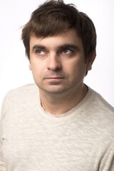 Fototapeta premium Close-up of a man in casual clothing, neutral background, with a contemplative look. Perfect for editorial use or as a representation of modern men’s fashion and emotions