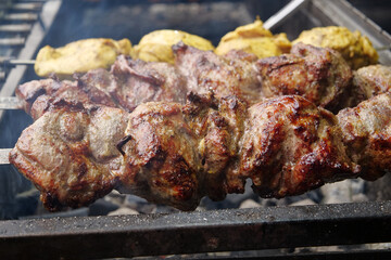 Delicious hot kebabs. Meat are cooked on coals in barbecue, rotates on skewers