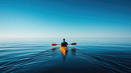 A man paddles through the ocean in a bright orange kayak, gliding across calm waters under a clear blue sky, capturing the spirit of adventure