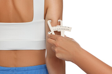Nutritionist measuring woman's body fat with caliper on white background, closeup