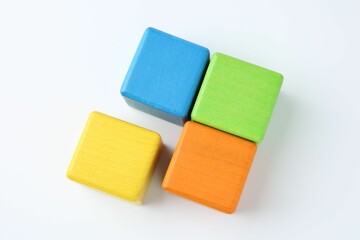 Many wooden colorful cubes on white background, top view