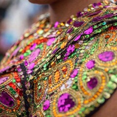 A shoulder-level extreme macro shot of shimmering sequins on a dancer's costume at the Rio Carnival, with shallow focus bringing attention to the dazzling details. The image captures the essence of