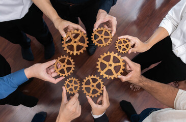 Business team joining cogwheel in circular together symbolize successful group of business...