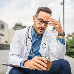 drunk man doctor drink alcohol from flask during workday