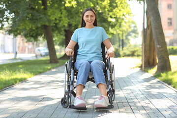 Obraz premium Young woman in wheelchair enjoying sunny days outdoors
