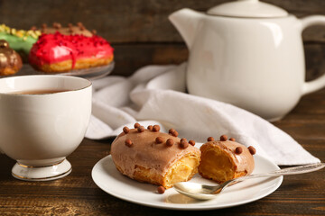 Sweet eclairs and tea on wooden background