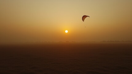 A warm sun ascends in the horizon, casting a golden glow as a paraglider glides gracefully above
