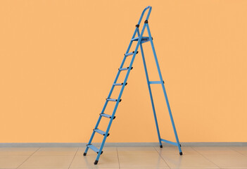 Blue stepladder near orange wall