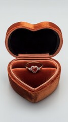Elegant heart shaped ring box with a ruby and diamond engagement ring inside it
