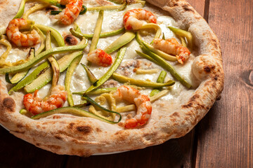 Deliziosa pizza gourmet italiana condita con mozzarella, zucchine e scampi 