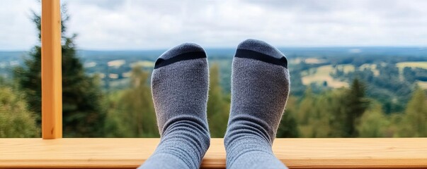 Feet in socks on a wooden deck, overlooking a scenic outdoor view
