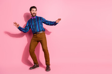 Full length photo of cheerful crazy elegant man wear stylish clothes have fun empty space isolated on pink color background