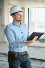 Engineer with tablet, building inspection. Construction man in helmet build new house