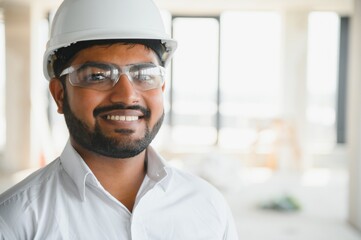 Construction concept. Portrait of a young architect at a construction site