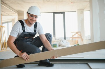 male construction worker wearing uniform Install gypsum ceiling inside the house and building