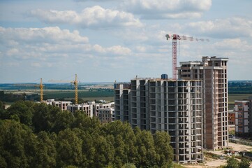 Tower cranes in close-up on the background of a multi storey building under construction