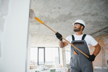 painter doing painting work on wall with roller. concept of hard working, home renovation