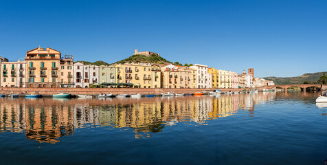 Obraz premium Panoramic view of the picturesque town of Bosa with its colorful houses reflected in the Temo River, Sardinia, Italy.