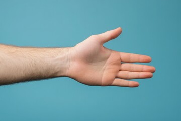 An extended hand is poised for a handshake against a solid blue background. This gesture symbolizes friendship, trust, and collaboration. It conveys the intention to connect and engage positively.