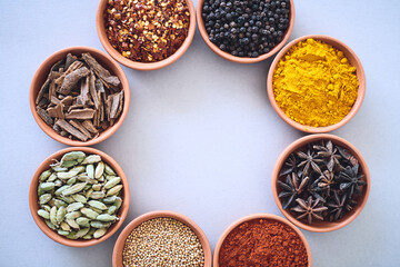 Spices, ingredients and circle of herbs seasoning on studio background for cooking and top view mockup. Variety, organic condiments and flavor selection with cinnamon, masala powder and peppercorns