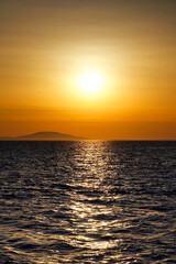 Fototapeta premium Beautiful shiny warm color sunset above wavy sea surface