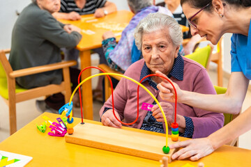 Senior woman and physiotherapist playing skill board games
