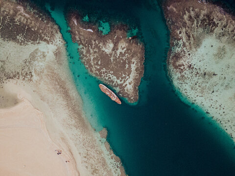 Aerial view of a shipwreck rusting in shallow water near Al Qattan beach