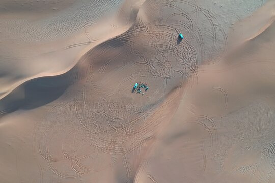 Aerial view of cars drifting on the sand in the riyadh desert