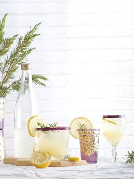 Clear drinking glass and bottle with lemon juice.
