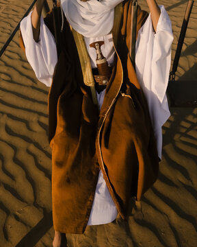 Close-up on a person in Abaya sits on a desert swing