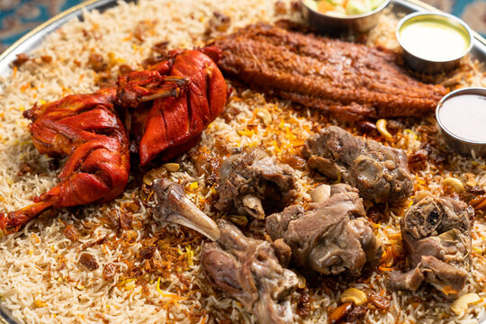 Close-up on Arabian assorted grill mandi with a side of sauces and vegetables