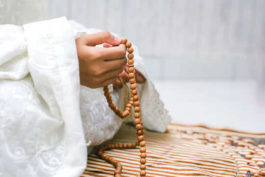 Cutout image of a person holding prayer beads