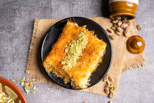 Flat lay of a piece of Kunafa in a black platter